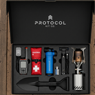 Protocol Kit Co. survival kit with various tools and equipment on a wooden surface